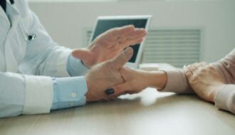 Doctor providing comfort holding patient hands