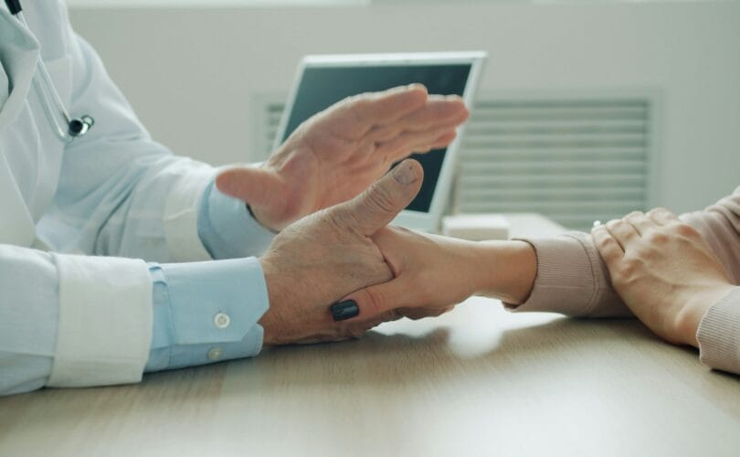 Doctor providing comfort holding patient hands